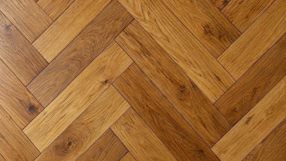 Close-up of medium brown oak boards laid in a tight herringbone pattern