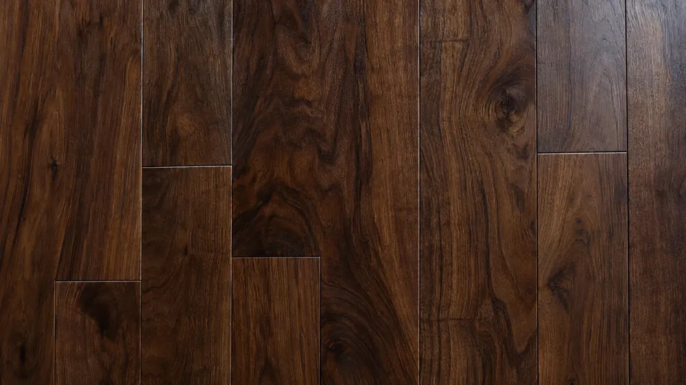 Close-up of dark brown walnut floorboards with deep swirling grain and subtle seams